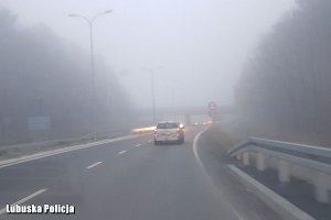 Auta na drodze spowitej gęstą mgłą