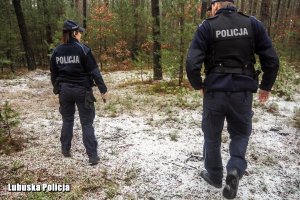 Policjanci w lesie zimową porą.
