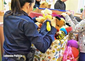 Policjantka  podczas wręczenia zebranych zabawek