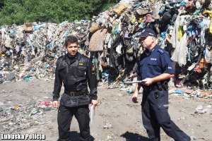 Strażak i policjant podczas kontroli składowiska odpadów