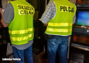 policjant i funkcjonariusz Krajowej Administracji Skarbowej podczas oględzin automatów do gier