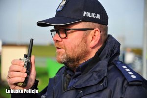 policjant podaje komunikat przez radiostację