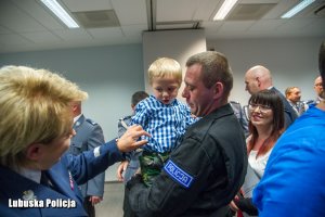 Policjant z dzieckiem na ręku