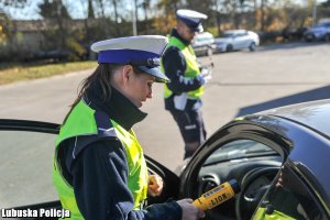 Policjantka ruchu drogowego sprawdza wynik badania na zawartość alkoholu w wydychanym powietrzu