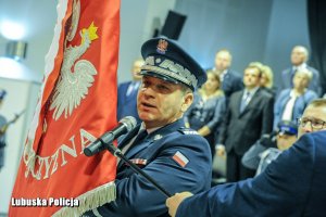 Policjant ze sztandarem Komendy Powiatowej Policji w Sulęcinie