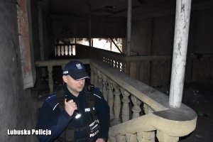 Policjant kontroluje opuszczony budynek