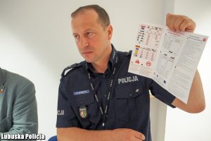 Policjant pokazujący taryfikator mandatów
