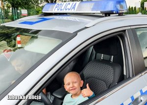 Chłopiec w policyjnym radiowozie.