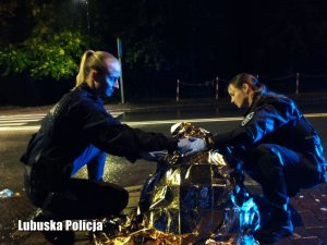 Policjantki przykrywają kocem medycznym poszkodowanego