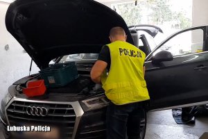 Policjant podczas oględzin odzyskanego po kradzieży auta