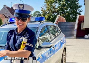 Policjantka ruchu drogowego przy radiowozie.