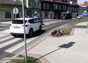 Miejsce potrącenia rowerzystki - rower leżący przy jezdni, a na niej jadące pojazdy.