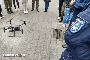 Policjanci drogówki omawiają zasady pracy z policyjnym dronem
