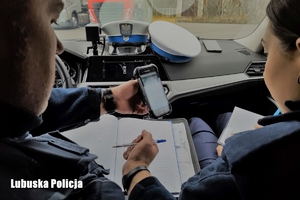 policjanci sporządzają dokumentację w radiowozie