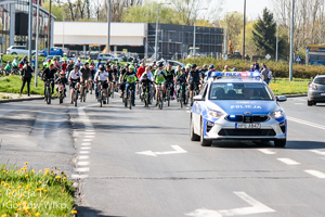 Policyjny radiowóz prowadzi peleton rowerzystów