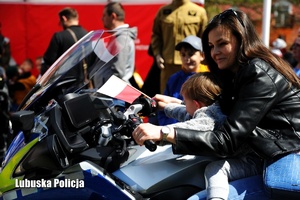 Kobieta z dzieckiem przy policyjnym motocyklu.