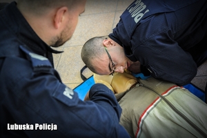 policjanci prowadzą pierwszą pomoc medyczną na manekinie