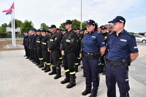 Policjanci i strażacy stojący w szeregu.