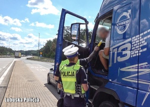 Policjanci drogówki podczas kontroli ciężarówki na autostradzie.