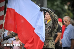 żołnierz wznosi flagę