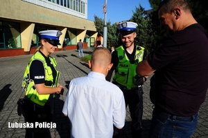 policjanci rozdają odblaski dzieciom