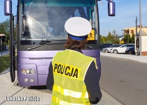 Policjantka drogówki stoi przed autobusem.
