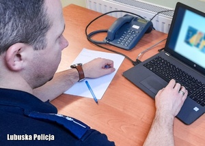 Policjant przed komputerem podczas odprawy przed ćwiczeniami sztabowymi.
