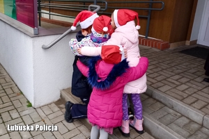 Policjantka przytula się do dzieci.