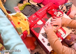 Prezenty świąteczne i ręce dziecka na jednym z prezentów.