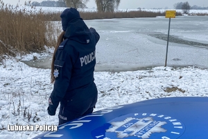 Policjantka pokazuję palcem na tafle lodu