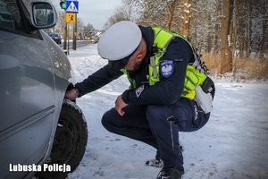 policjant kontroluje ogumienie pojazdu