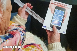Seniorka trzymająca broszurę informacyjną