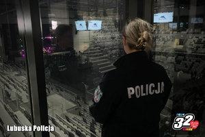 policjantka spogląda przez okno na halę sportową
