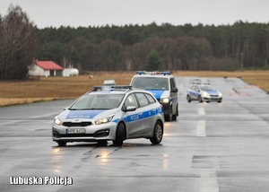Policyjne radiowozy jadące po jezdni w trakcie szkolenia.