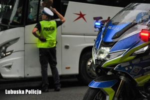 Motocykl, w tle widoczny policjant rozmawiający z kierowcą