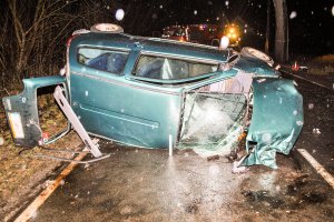 uszkodzony samochód osobowy wywrócony na bok