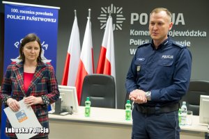 policjant i dziennikarka przemawiają do policjantów