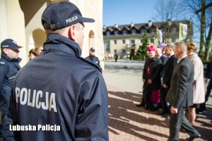 Policjant, a w tle inne osoby wchodzące do kościoła.