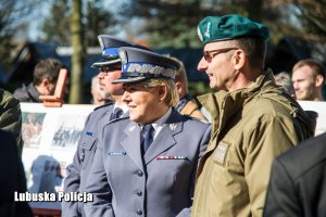 Policjantka obok żołnierza, w tle inne osoby.