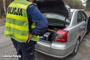 policjant  sprawdza bagażnik auta