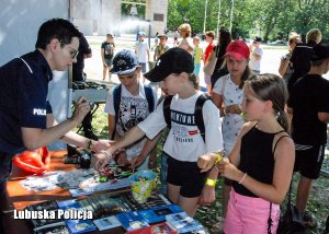 Policjanci rozmawiają z najmłodszymi o bezpieczeństwie na wakacjach.