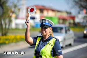 Policjantka zatrzymuje pojazd do kontroli drogowej.