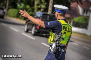Policjant daje sygnał ręką.