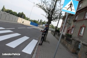 policjant sprawdza oznakowanie w rejonie szkoły