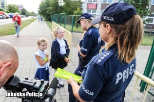 Policjantki wręczają dzieciom elementy odblaskowe.