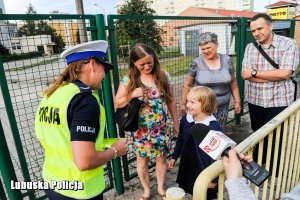 Policjantki wręczają dzieciom elementy odblaskowe.