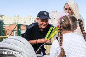 Policjantki wręczają dzieciom elementy odblaskowe.