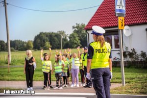 Policjantka i dzieci na przejściu dla pieszych.
