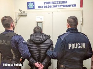 Zatrzymany mężczyzna z policjantami.