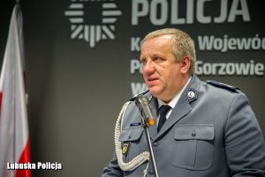 Policjant przemawia do zebranych osób.